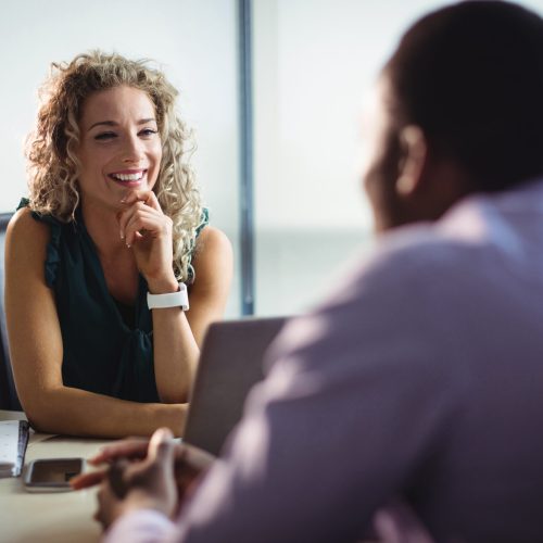 Business executives interacting with each other in office